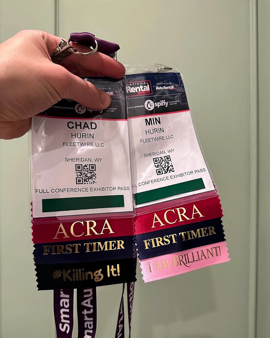Chad's and Min's exhibitor badges with ACRA First Timer ribbons